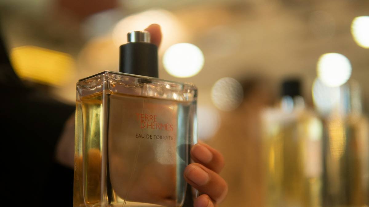 Man correctly applying men s cologne to neck pulse point with precise spray technique