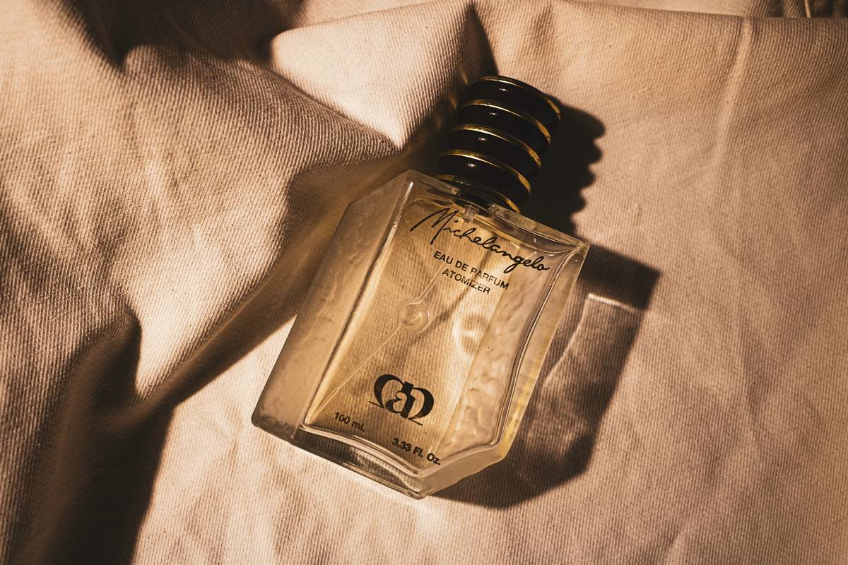 Fragrance wheel showing four main scent families: Fresh, Woody, Oriental, Aromatic with subcategories like citrus, marine, leather, tobacco